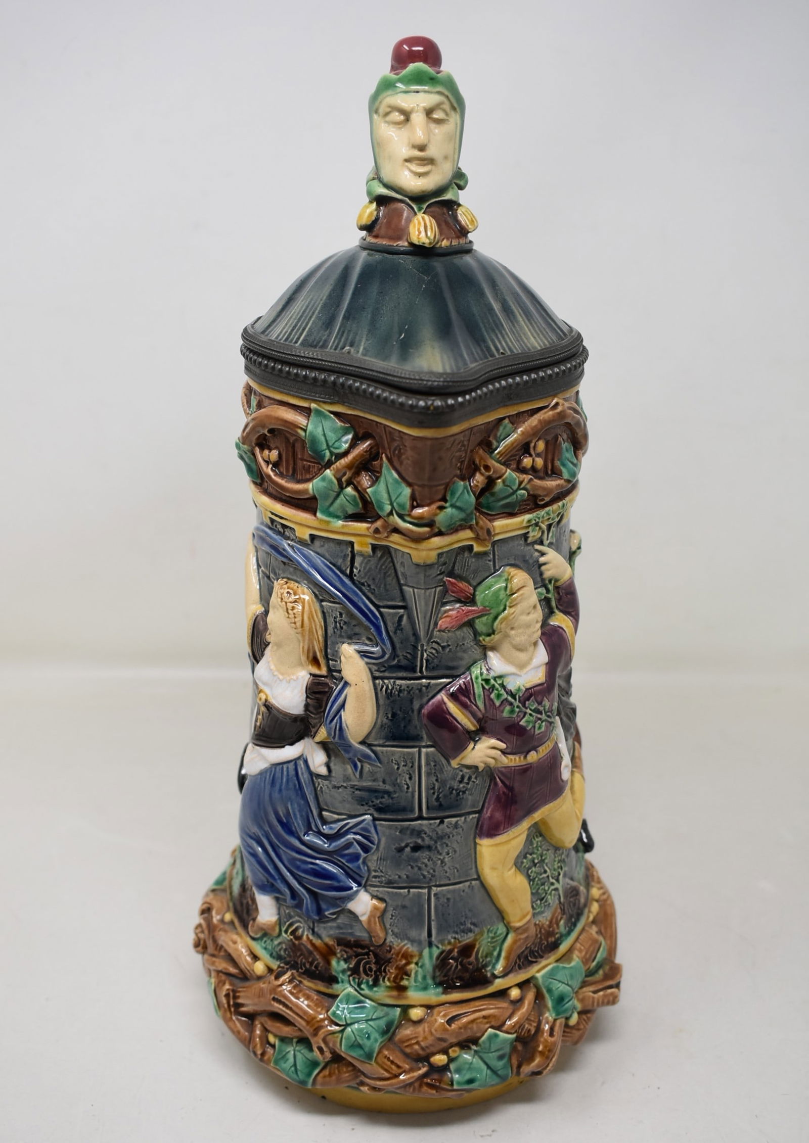 Minton Majolica Beer Stein Pitcher 19th Century: Minton Beer Stein with Jester on Lid. Polychrome decoration on figural scene body. It is marked and numbered on the body base. Very nice piece! Has a very faint hairline on lid, see photo.