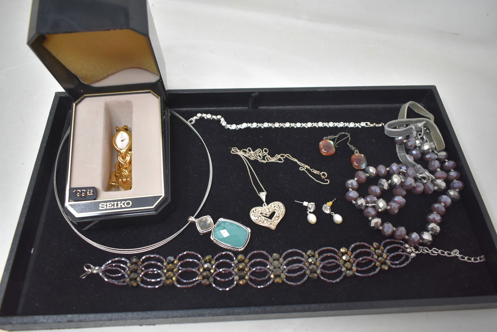 Lot of Women's Sterling & Costume Jewelry: Lot Women's Sterling and Costume Jewelry. The heart pendant and chain are sterling. Also includes Seiko Watch.