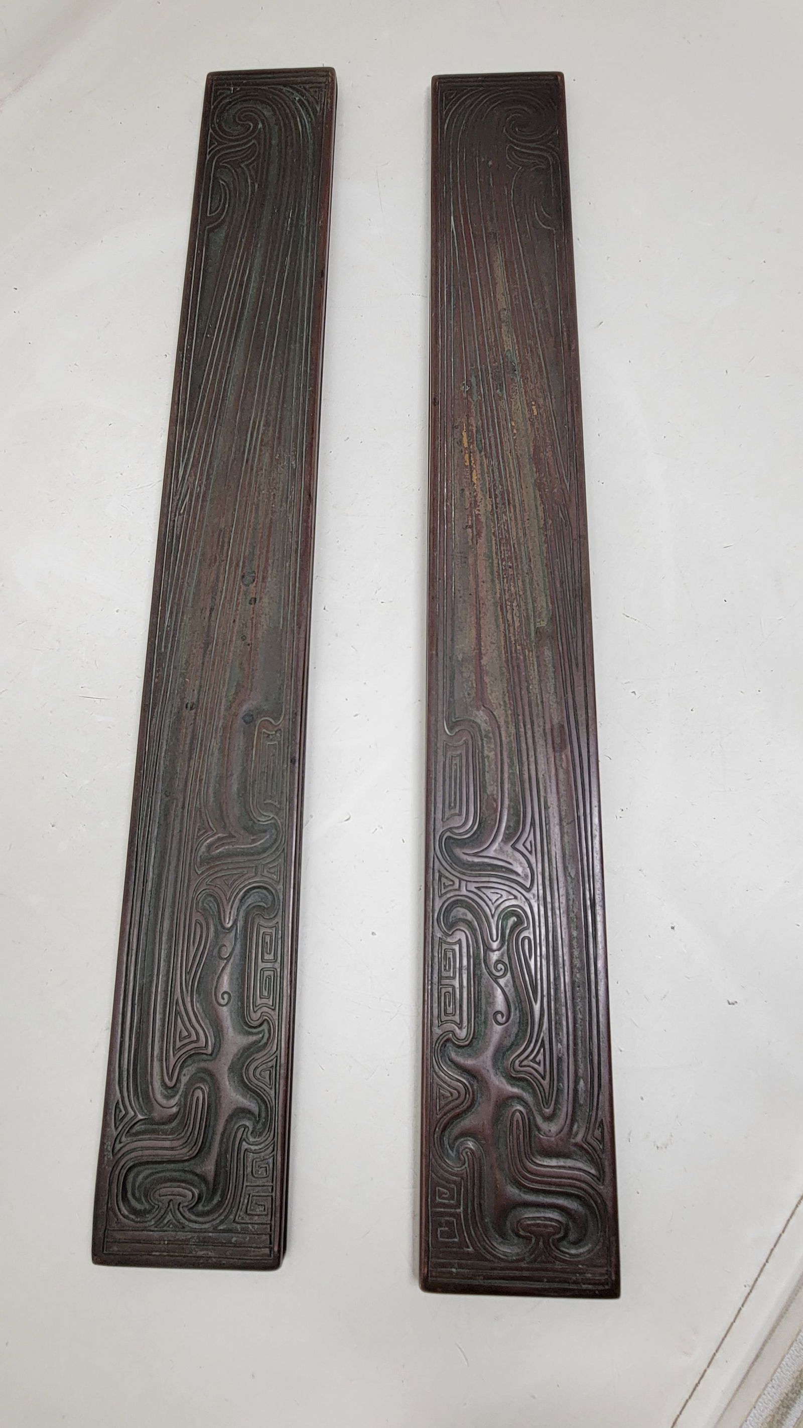Beautiful Tiffany Studios New York "Chinese" Pattern Bronze Desk Blotter Ends Signed: Beautiful Tiffany Studios New York "Chinese Pattern" Bronze Desk Blotter Ends Signed. They feature stylized flowing lines and Japanese motifs. 19.5" long, c. 1910. In nice condition.