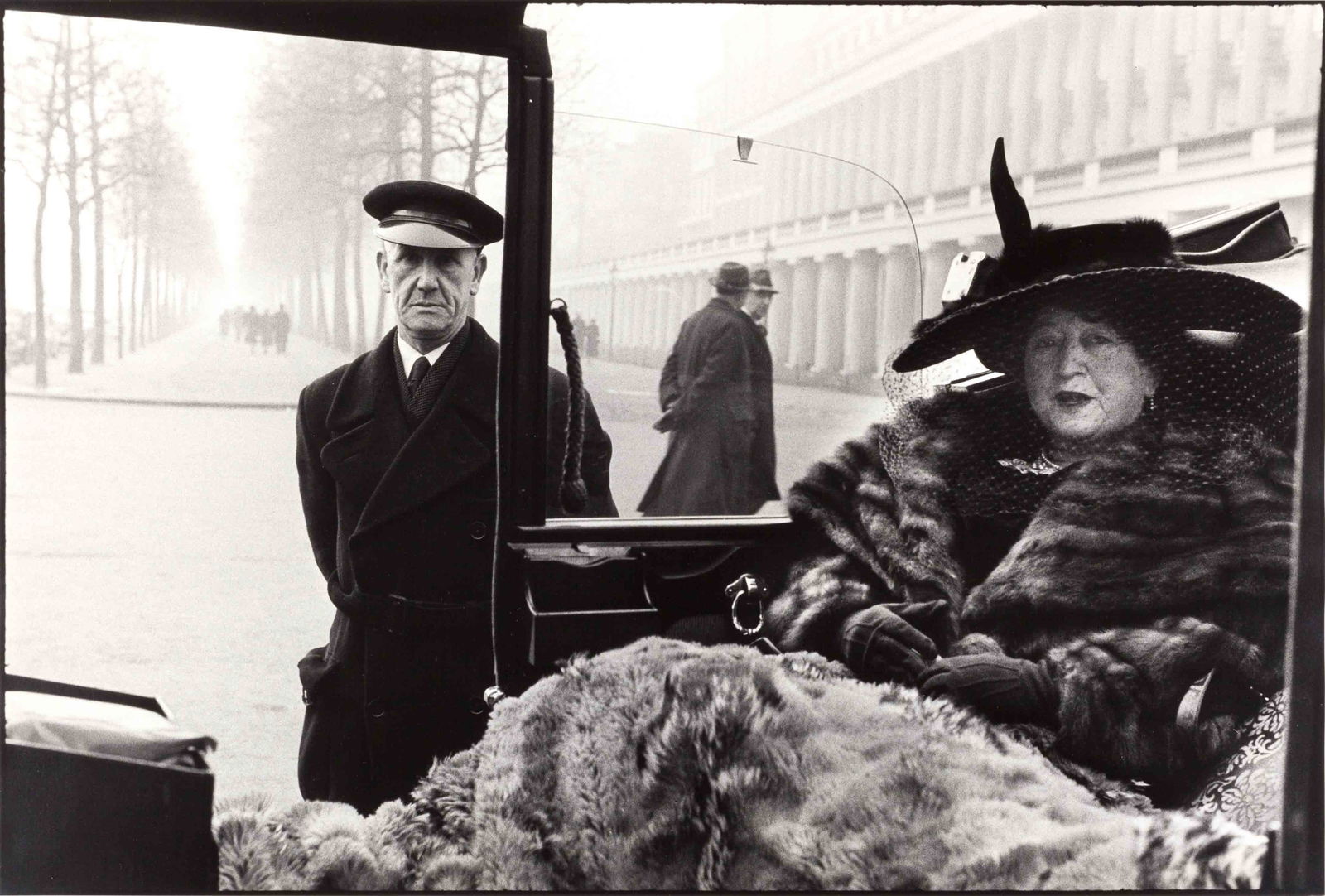 INGE MORATH (1923–2002): INGE MORATH (1923–2002) | Mrs. Evelyn Nash with her chauffeur, London 1953 Image Size: 38,4 x 56,6 cm English: Gelatin silver print, printed 1989 on double-weight semi-matte paper 50,7 x 60,5 cm