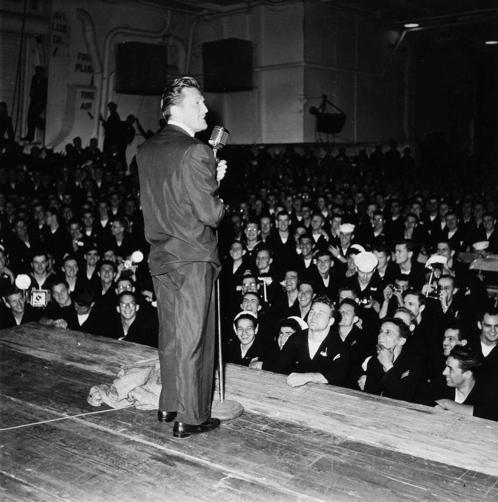 MICHOU SIMON | Kirk Douglas entertaining U.S. sailors during the Cannes Film Festival, France, 1953 (1 of 1)
