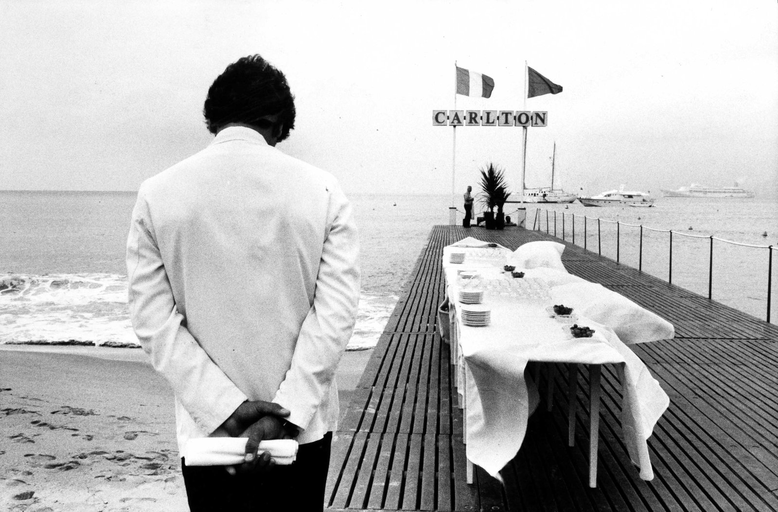 GUY LE QUERREC (*1941): GUY LE QUERREC (*1941) | Preparations at the Carlton Hotel pier, Cannes 1980 Image Size: c. 14.5 x 21.5 cm English Vintage gelatin silver print, 17.5 x 23.9 cm, in very good condition. Photographer's