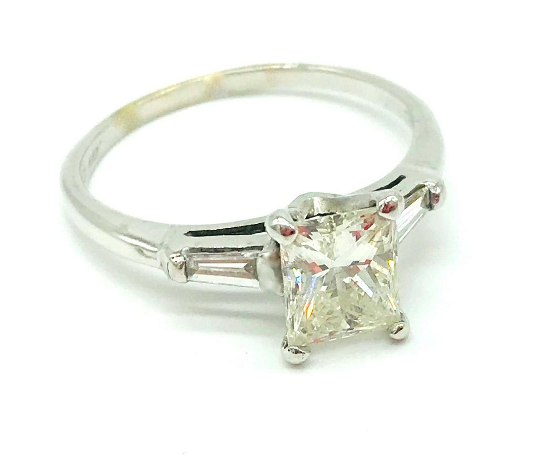 Platinum, Emerald Cut 1.18 Ct. Solitaire with Accents: Platinum, Princess Cut 1.18 Ct. Solitaire with Accents Ring Engagement ring consists of a solitaire Modified Princess Cut weighing 1.18 carat. The Quality of the diamond is SI1 clarity and H color. Ri