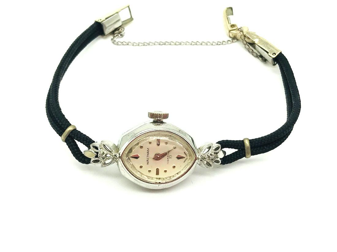 Waltham, 17 Jewel Vintage Diamond Watch: Waltham, 17 Jewel Vintage Diamond Watch Sweet ladies watch with (4) diamonds on either sides of lugs. Manual wind, 17 jewel watch works!. Base metal. Black cord strap. Safety chain. GIA Gemologist Ins