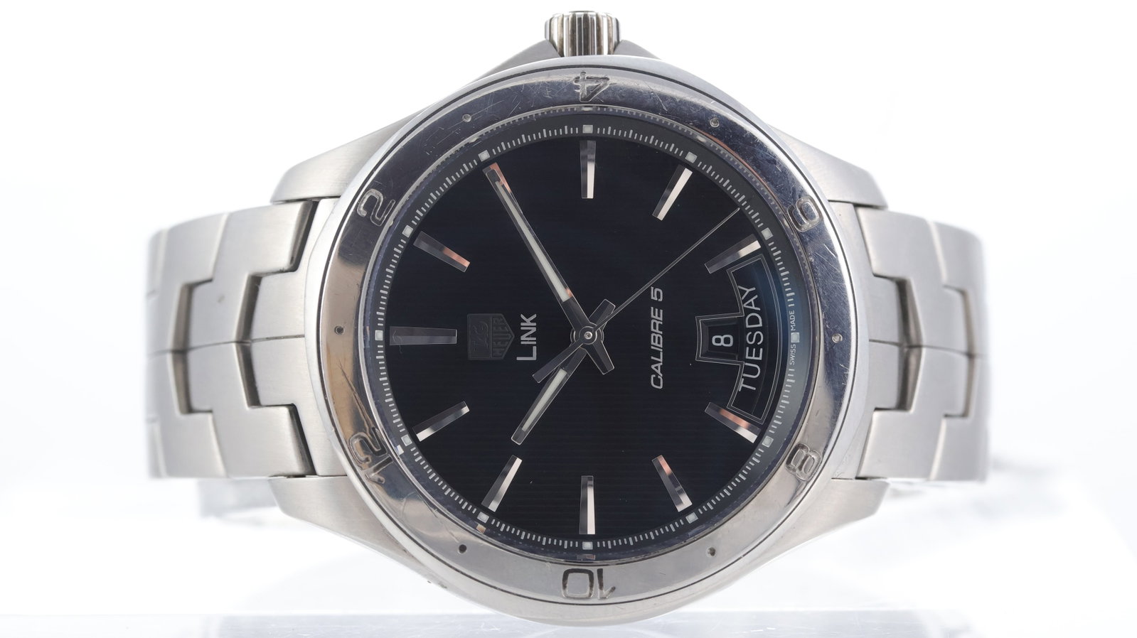 Tag Heuer Link Day & Date Automatic Ref WAT2010-0: Brand: Tag Heuer Model Name: Link Reference: WAT2010-0 Movement type: Automatic Movement calibre: Tag Heuer 5 Dial shape: Circular Dial colour: Black Dial features: 'Teak' textured dial. Applied, face