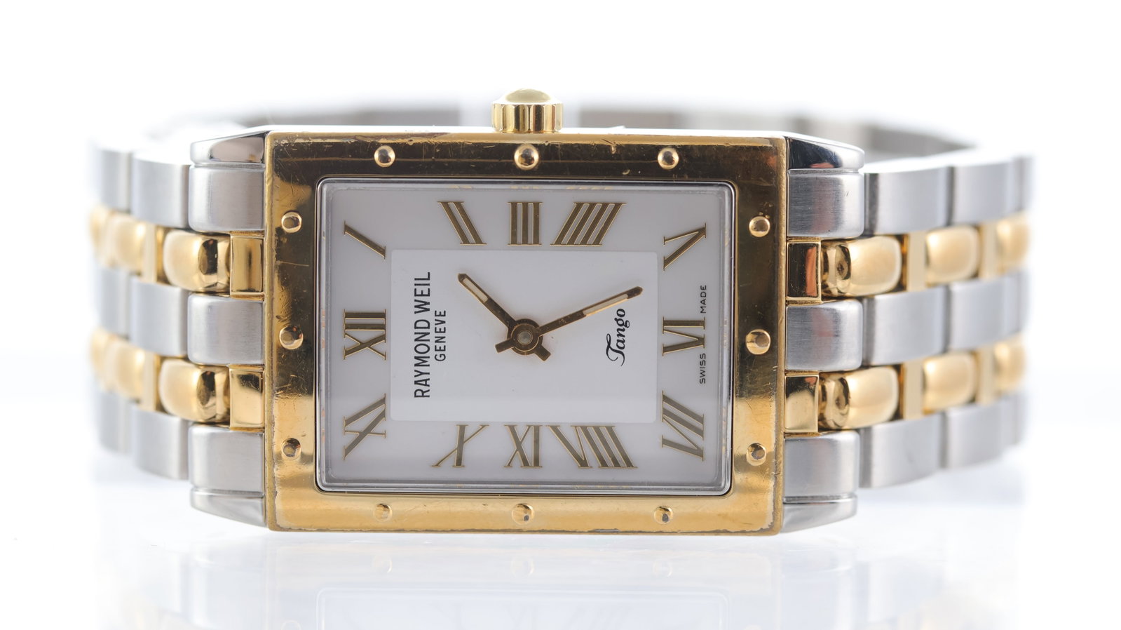 Raymond Weil Tango Ref 5980: Brand: Raymond Weil Model Name: Tango Reference: 5980 Movement type: Quartz Dial shape: Rectangular Dial colour: White Dial features: Roman numerals, quickset date at 3 o'clock Bezel: Gold bezel Case