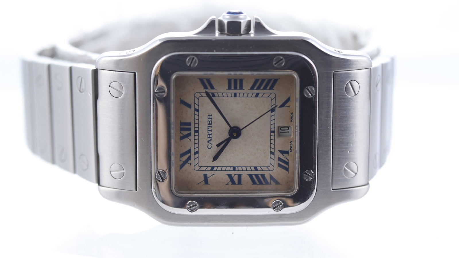 Cartier Santos Galbee Quartz: Brand: Cartier Model Name: Santos Galbee Movement type: Quartz Dial shape: Square Cushion Dial colour: Off-white (patina) Dial features: Blue roman numeral hour markers with a date aperture at 6 o'clo