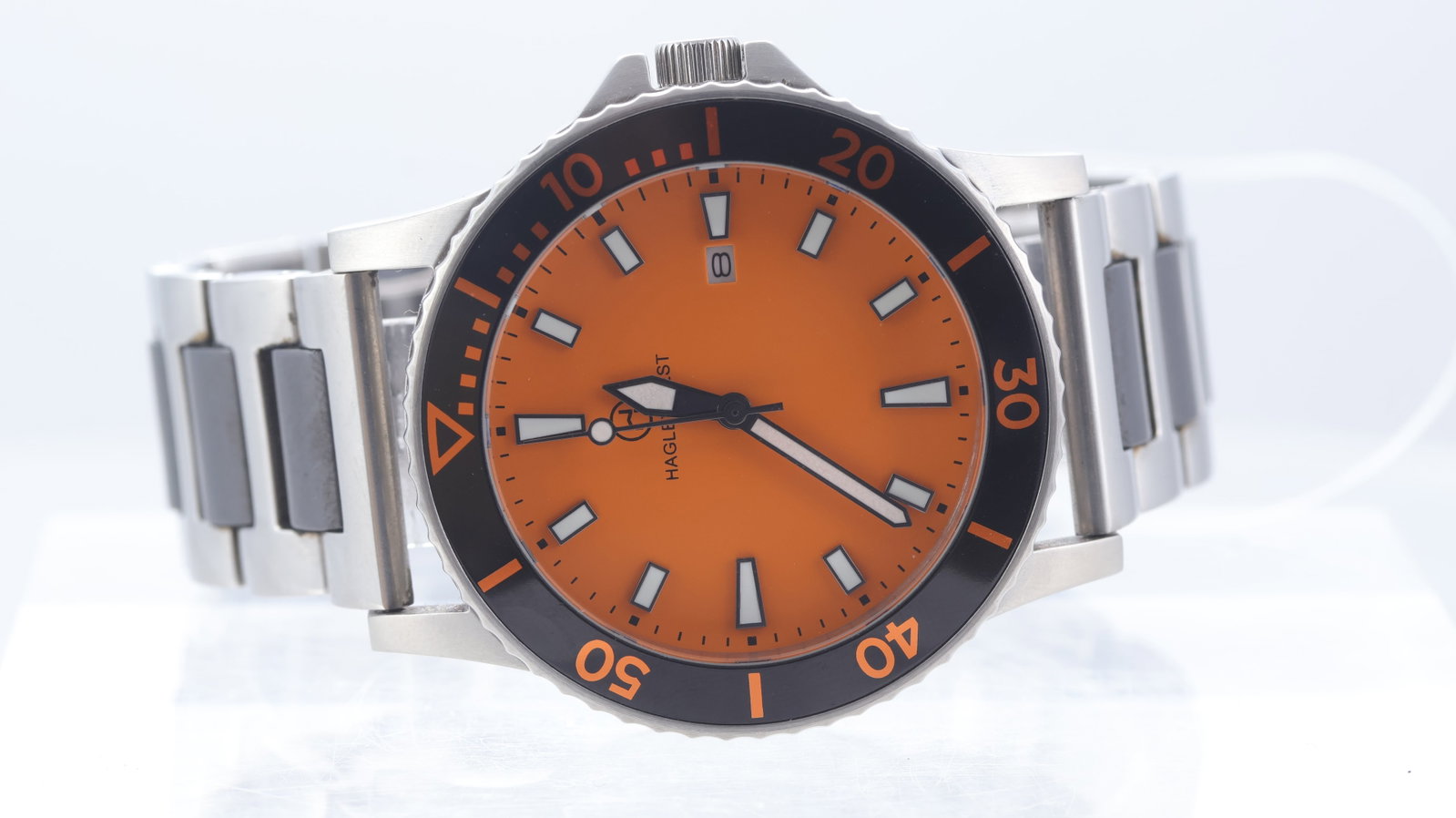 *To Be Sold Without Reserve* Hagley West Diver Quartz Date: Brand: Hagley West Model Name: Diver Movement type: Quartz Dial shape: Circular Dial colour: Orange Dial features: Applied hour markers. Date aperture at 3 o'clock. Bezel: Uni-directional bezel with