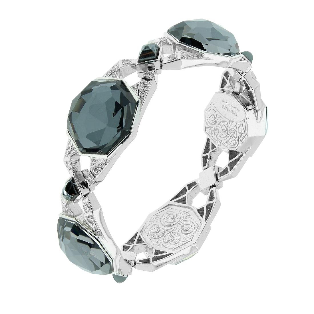A HEMATITE, ROCK CRYSTAL AND DIAMOND BRACELET, STEPHEN: A HEMATITE, ROCK CRYSTAL AND DIAMOND BRACELET, STEPHEN WEBSTER in 18ct white gold, comprised of five links set with a large mixed octagonal cut rock crystal between diamond set shoulder, punctuated wi