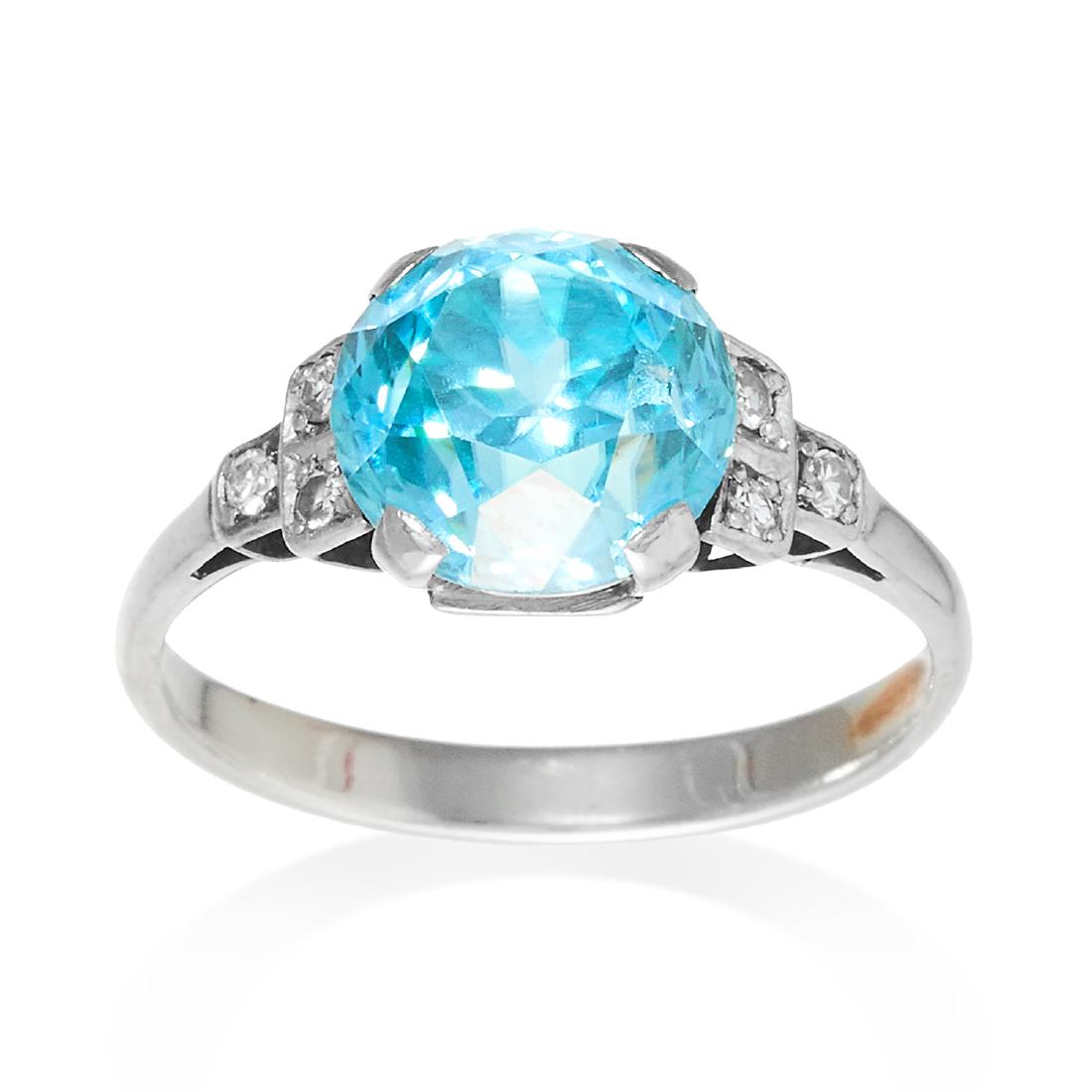 AN ART DECO BLUE ZIRCON AND DIAMOND RING in white gold: AN ART DECO BLUE ZIRCON AND DIAMOND RING in white gold or platinum, set with a round cut blue zircon with six old cut diamonds to the shank, unmarked, size M / 6, 3.4g.