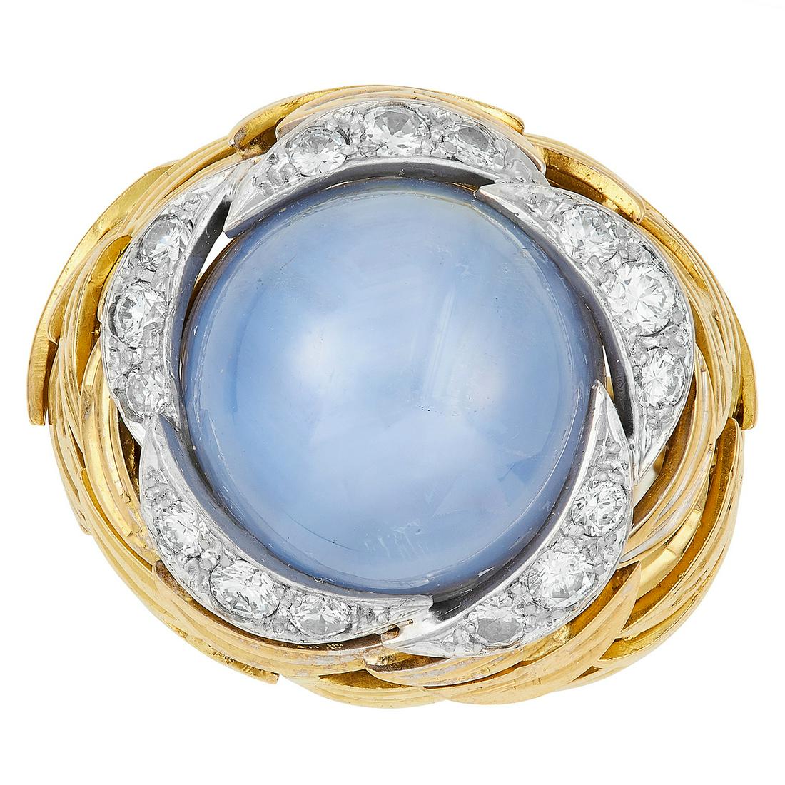 STAR SAPPHIRE AND DIAMOND COCKTAIL RING, GRIMA, 1979 in: STAR SAPPHIRE AND DIAMOND COCKTAIL RING, GRIMA, 1979 in 18ct yellow gold set with a central cabochon star sapphire of approximately 34.0 carats surrounded by round cut diamonds, signed Grima, full Bri