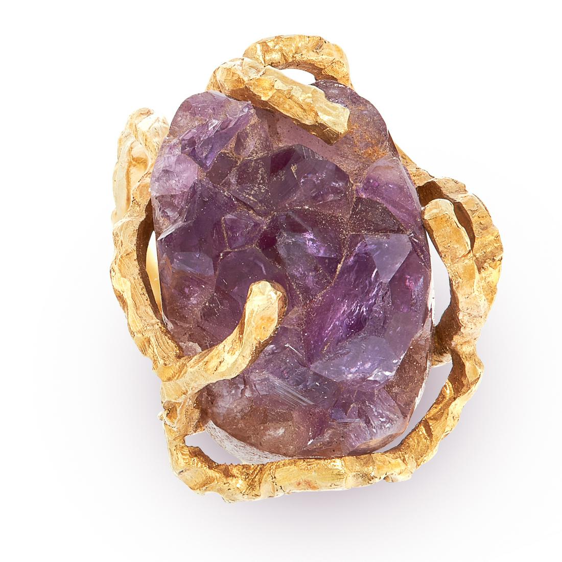 A VINTAGE AMETHYST RING AND PENDANT / BROOCH SUITE in: A VINTAGE AMETHYST RING AND PENDANT / BROOCH SUITE in 18ct yellow gold, in the style of Andrew Grima, each set with a rough piece of amethyst crystal, within textured gold mounts, stamped 750, pendant