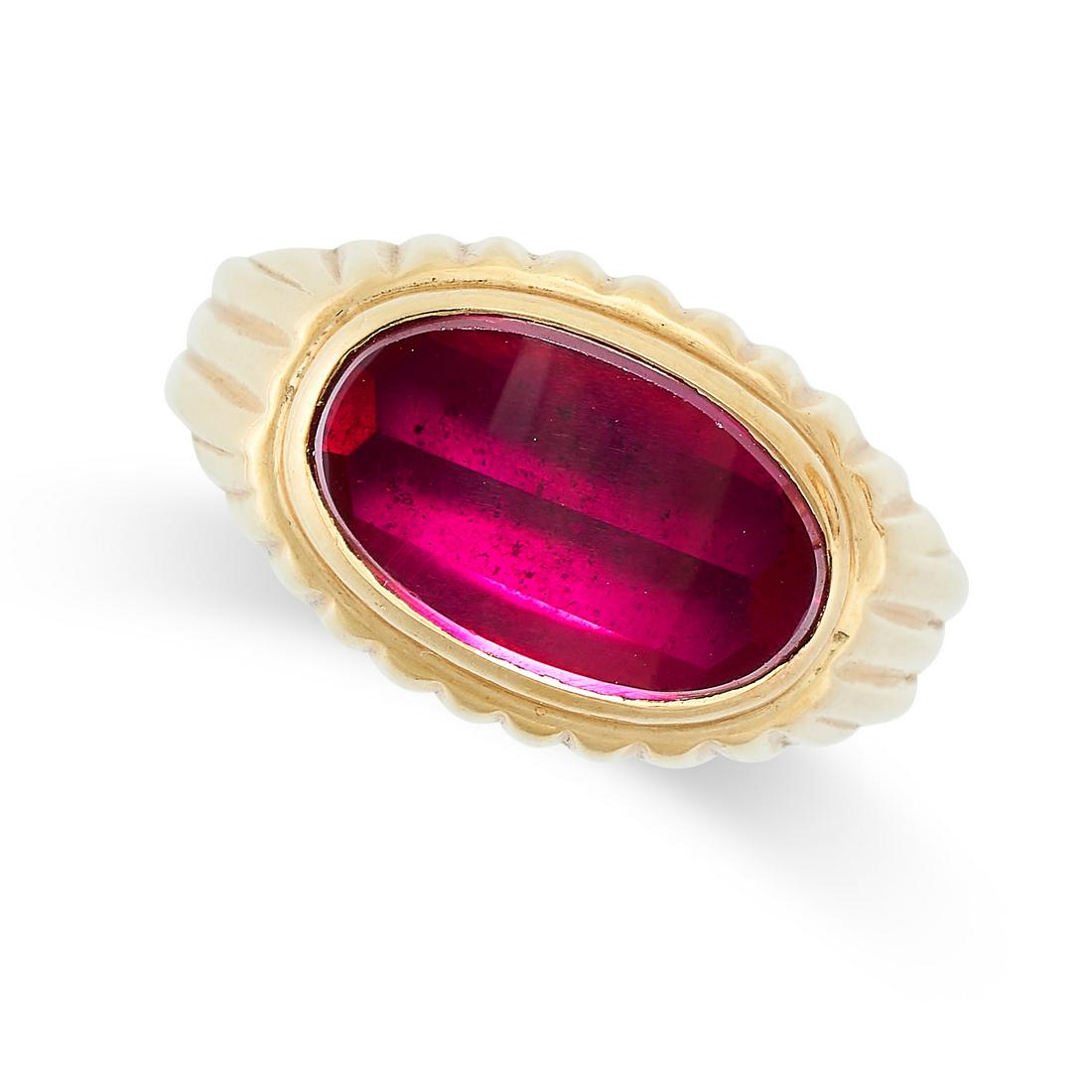 A VINTAGE SYNTHETIC RUBY RING in yellow gold, set with an oval shaped synthetic ruby on a fluted (1 of 2)