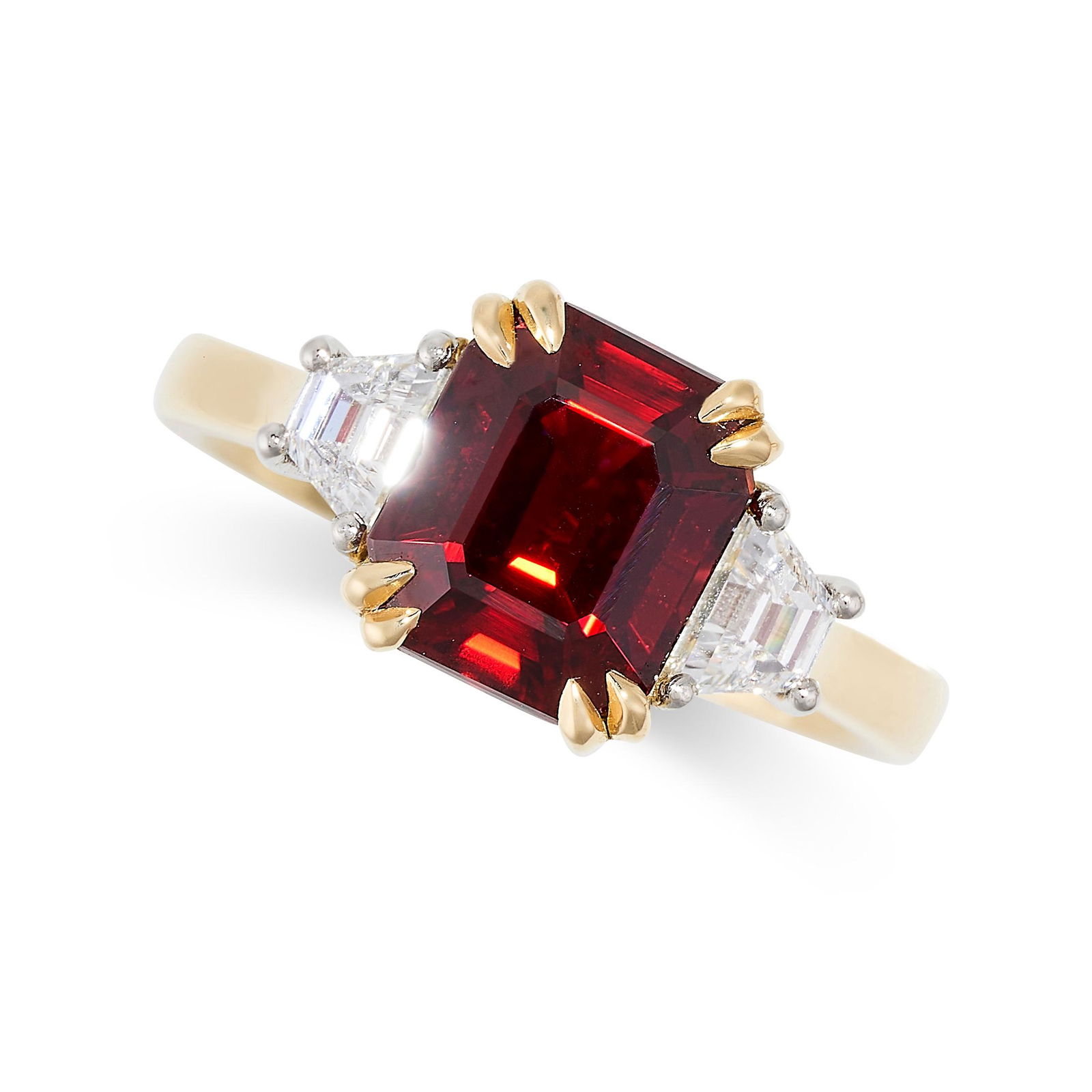 A RUBY AND DIAMOND THREE STONE RING in 18ct yellow gold, set with an emerald cut ruby of 3.37 carats: A RUBY AND DIAMOND THREE STONE RING in 18ct yellow gold, set with an emerald cut ruby of 3.37 carats between two trapeze cut diamonds both totalling 0.4-0.5 carats, full British hallmarks, size M / 6,