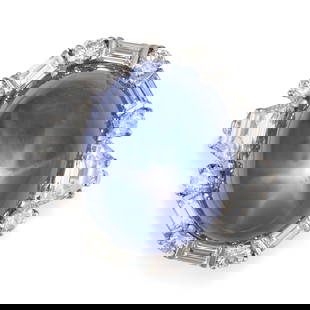 BULGARI, AN IMPORTANT STAR SAPPHIRE AND DIAMOND RING in platinum, set with a cabochon star sapphire: BULGARI, AN IMPORTANT STAR SAPPHIRE AND DIAMOND RING in platinum, set with a cabochon star sapphire of approximately 67.71 carats in a border of round brilliant, baguette and trapezoid diamonds, the d