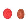 A MOULDED GLASS INTAGLIO AND A CARVED SCARAB BEETLE the red glass intaglio moulded to depict Cupid