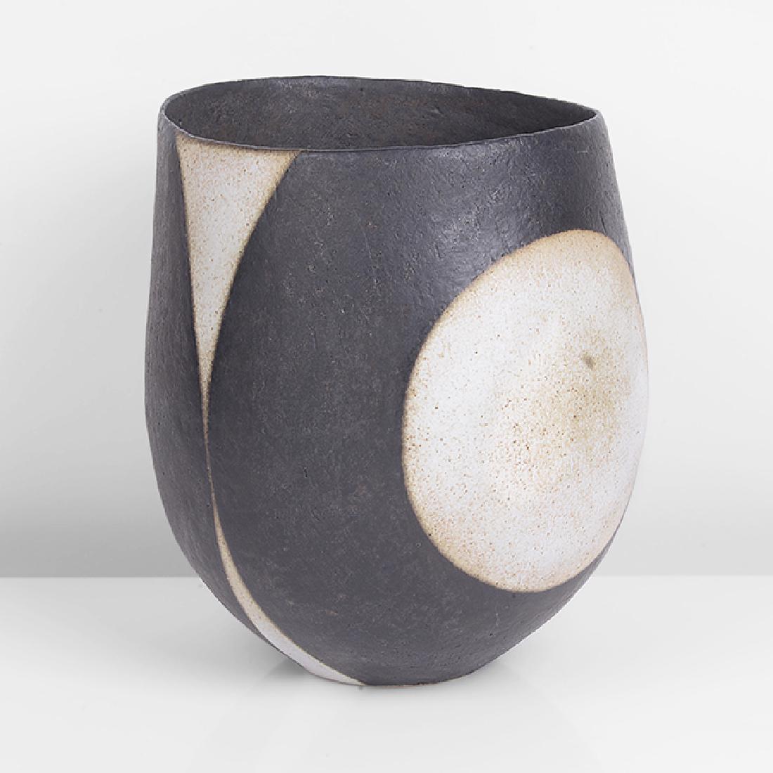 John Ward (British, b.1938): Asymmetric Pot, circa 1995 Stoneware, deep bowl form with leaning asymmetric rim, circular bands of matt black and white glaze over a softly textured surface, impressed JW seal H 21.3cm, D 17.2cm PROV