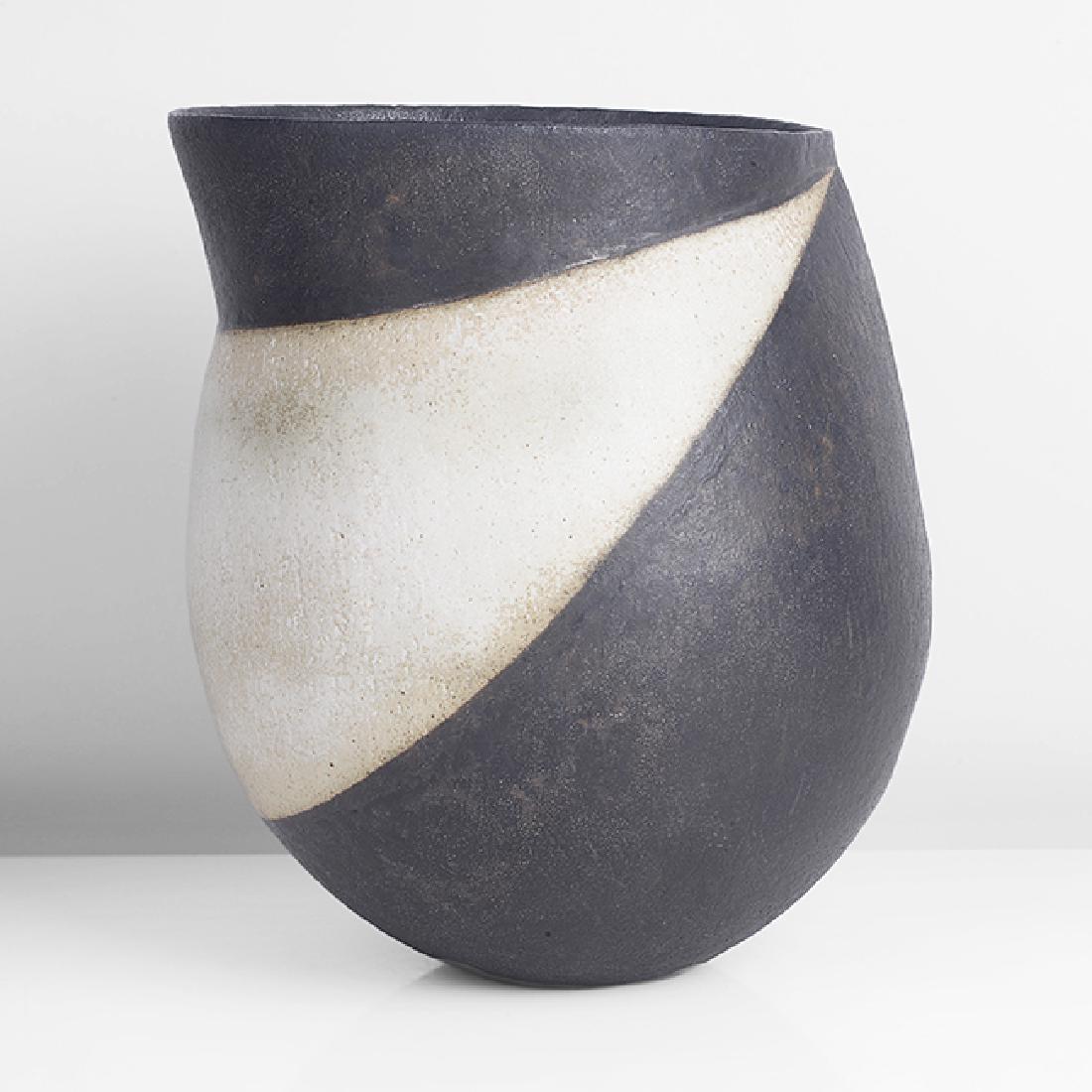John Ward (British, b.1938): Vessel with Angled Rim, circa 1992 Stoneware, matt black and white glaze over a softly textured surface, rounded form set with an angled collar, a sharp ridge running down from the edge over one shoul