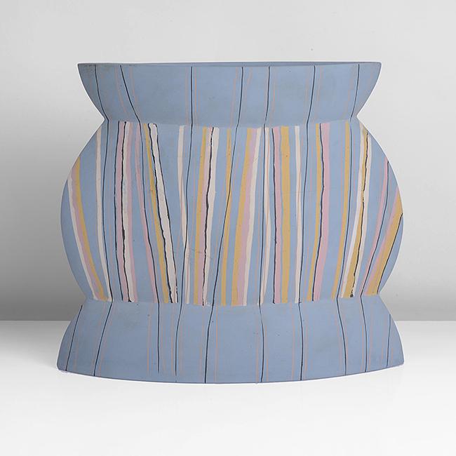 Felicity Aylieff (British, b.1954): Flattened Vessel, circa 1985 Earthenware, blue body inlaid with linear design in cream, pink, yellow and black, incised signature Dimensions: H 22.4cm, W 25.8cm, D 8.8cm Bidding: To place a bid in thi