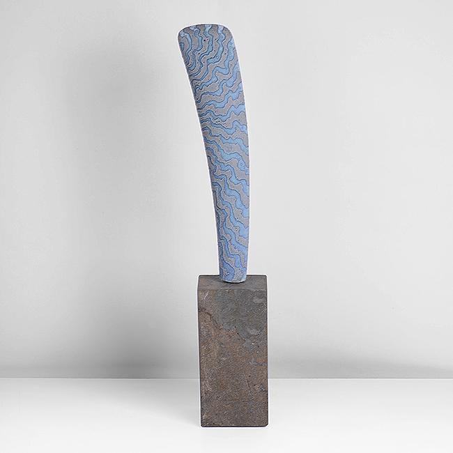 Peter Beard (British, b.1951): Sail Form Stoneware, undulating bands of mottled blue and grey to a textured surface, mounted by a metal pin on a rectangular stone base Dimensions: H incl. base 45.3cm, W 7.6cm, D 6.2cm Bidding: To p