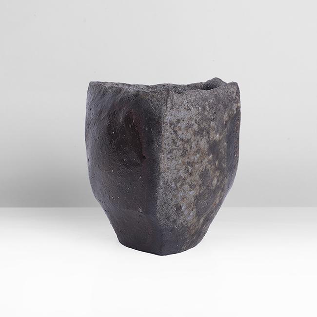 Tim Rowan (American, b.1967): Cup, 2012 Stoneware, woodfired mottled glazes in brown, black and grey, cutsided form, impressed maker's seal Dimensions: H 7.8cm, W 7.4cm, D 6.7cm PROVENANCE: The Dayabandhu (Michael Evans) Collectio