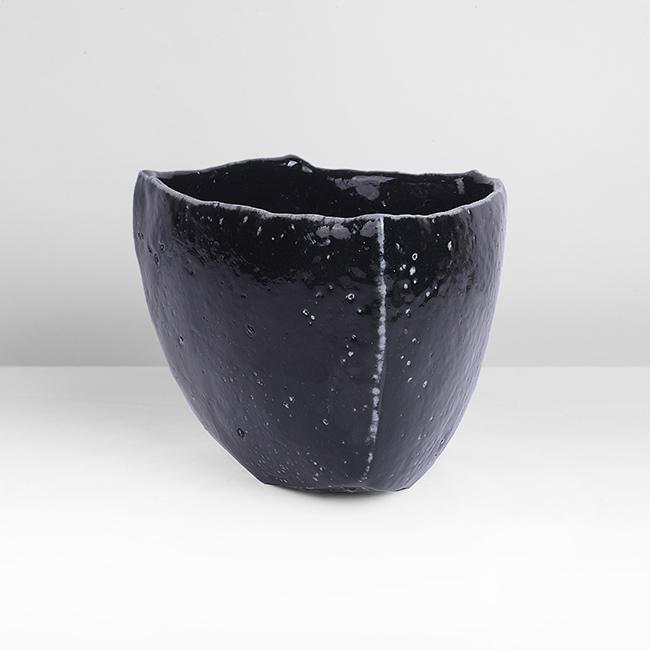 Tim Rowan (American, b.1967): Tea Bowl, 2012 Stoneware, dark greenish black saltglaze, angular form with a triangular base, impressed maker's seal Dimensions: H 9.7cm, W 11.5cm, D 11.1cm PROVENANCE: The Dayabandhu (Michael Evans)
