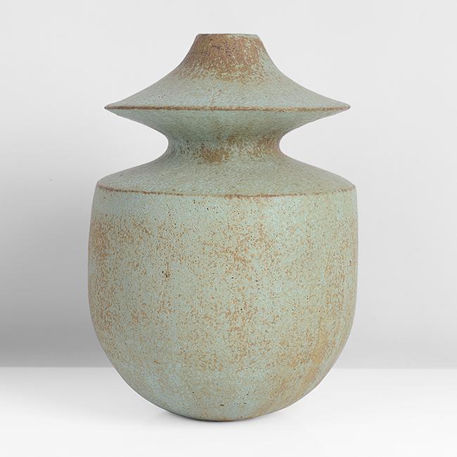 John Ward (British, 1938) Pot with flared Collar, circa: Stoneware, mottled green and brown matt glazes over a lightly textured surface, a flared and tapered collar above the flattened shoulder, impressed JW seal Dimensions: H 22.0cm, D 14.8cm Notes: PROVEN