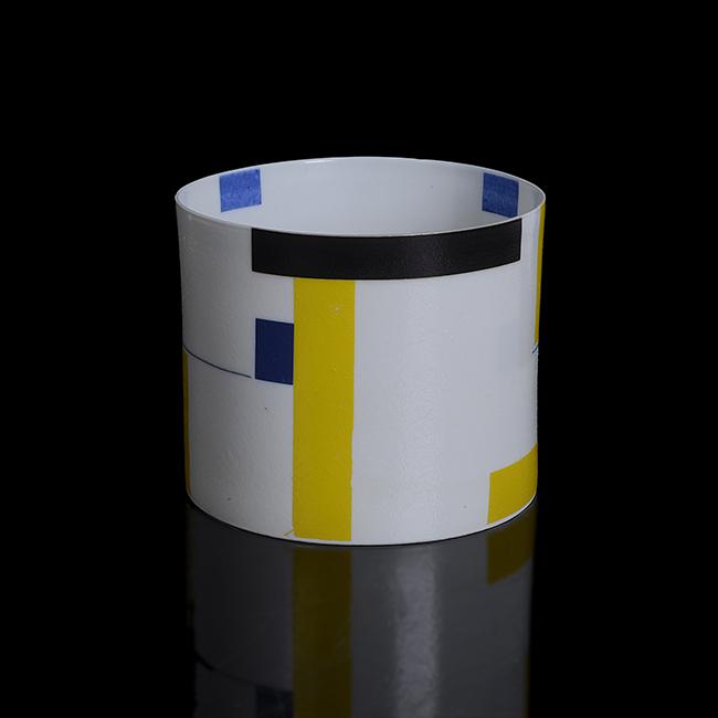 Bodil Manz (Danish, b.1943) 'Construction in Blue,: Porcelain, white glazed body with geometric blocks and lines in yellow, grey, black and blue, painted signature and date Dimensions: H 7.6cm, D 9.2cm Notes: PROVENANCE: Adrian Sassoon, London To place