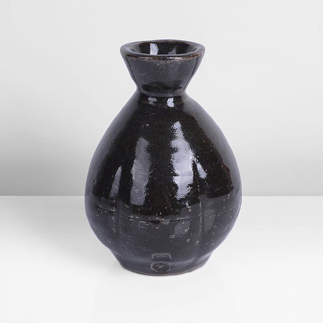 Bernard Leach (British, 1887-1979): Flower Vase, 1960 Stoneware, rich tenmoku glaze with an iron speckle, the bulbous body with repeated vertical impressions, impressed BL and Leach Pottery seals Size H 15.0cm, D 10,4cm Notes PROVENANCE