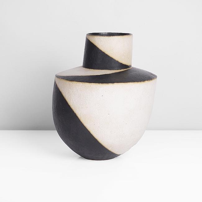 John Ward (British, b.1938): Asymmetric Collared Vessel Stoneware, matt black and white glazes in alternating bands, soft cream bleed where contrasting colours meet, impressed JW seal H 21.2cm, D 16.6cm PROVENANCE: Private Collec