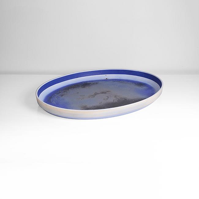 Bodil Manz (Danish, b.1943): Large Oval Charger Porcelain, mottled blue and brown glazes to the well graduating to white around the lip with a strong blue band around the rim, painted signature Dimensions: 5.0cm, W 8.1cm, D 45.4c