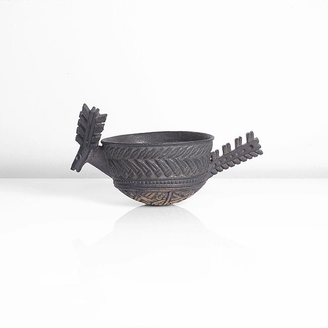 Ian Godfrey (British, 1942-1992): Antelope Cup, circa 1989 Stoneware, dark manganese glaze, the cup form with intricately carved designs, mounted with an antelope head with antlers and a carved handle DIMENSIONS: H 910.2cm, W 19.1cm,