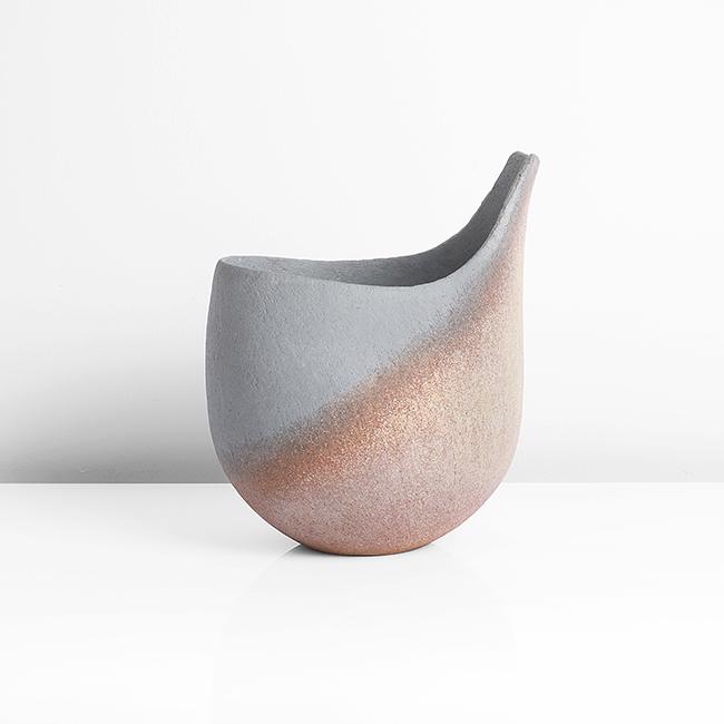 John Ward (British, b.1938): Lipped Vessel, circa 1995 Stoneware, mottled ochre and yellow glazes to a textured surface with pale blue-grey glaze to the interior and sweeping diagonally over the exterior up to the extended rim, i