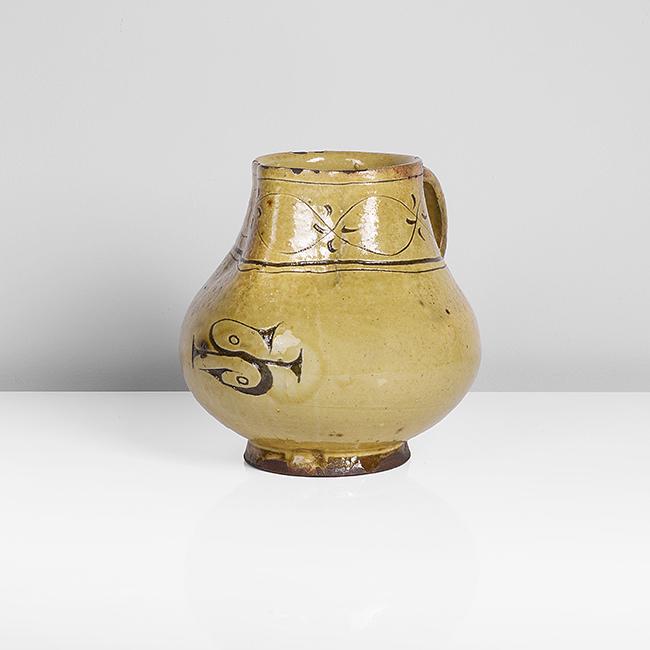 Bernard Leach (British, 1887-1979): Pitcher, circa 1922 Earthenware, yellow galena glaze over white slip, an incised Leach Pottery mark to the belly of the pitcher and band of decoration at the neck, impressed BL and Leach Pottery seals