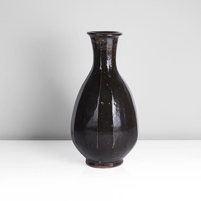 Bernard Leach (British, 1887-1979): Bottle Vase, circa 1960 Stoneware, layered tenmoku and iron glazes over a fluted body, impressed BL and Leach Pottery seals Dimensions: H 33cm, D 18cm PROVENANCE: Dr John P Driscoll Collection All bid