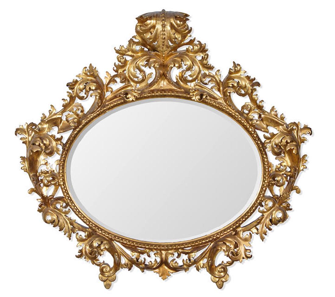 AN ITALIAN BAROQUE STYLE GILTWOOD OVAL MIRROR (1 of 2)
