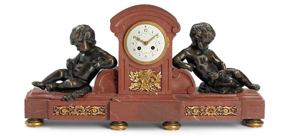 A Tiffany & Co. Gilt Bronze and Rouge Marble Clock: A French patinated and gilt bronze mounted rouge marble clock, retailed by Tiffany and Co., Early 20th century. Movement stamped with pastille inscribed "JAPY FRERES GDE MED D'HONNEUR" also "MADE IN F