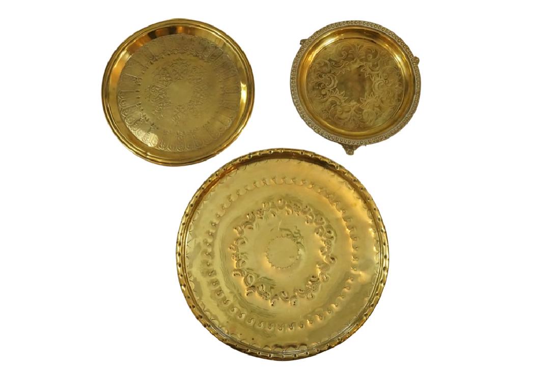 Two English Brass Engraved Trays and One English Pub: Lot 19 Two English Brass Engraved Trays and One English Pub Tray Raised on Scrolled Feet 19 C. Brass Pub Tray: l 1 x 10 1/8 x 10 1/8 in. Medium 3/4 x 11 3/4 x 11 3/4 in. Large 3/4 x 15 1/2 x 15
