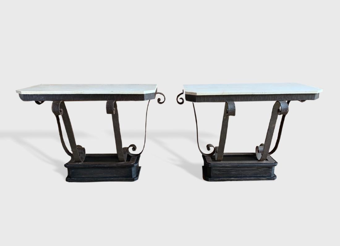 Pair Of Art Deco Iron And Stone Console Tables: A pair of Art Deco wrought iron and travertine stone top console tables, in the manner of Oscar Brandt, circa 1925, with ebonized wood platform bases. Dimensions: 45" w x 22" d x 32.5" h