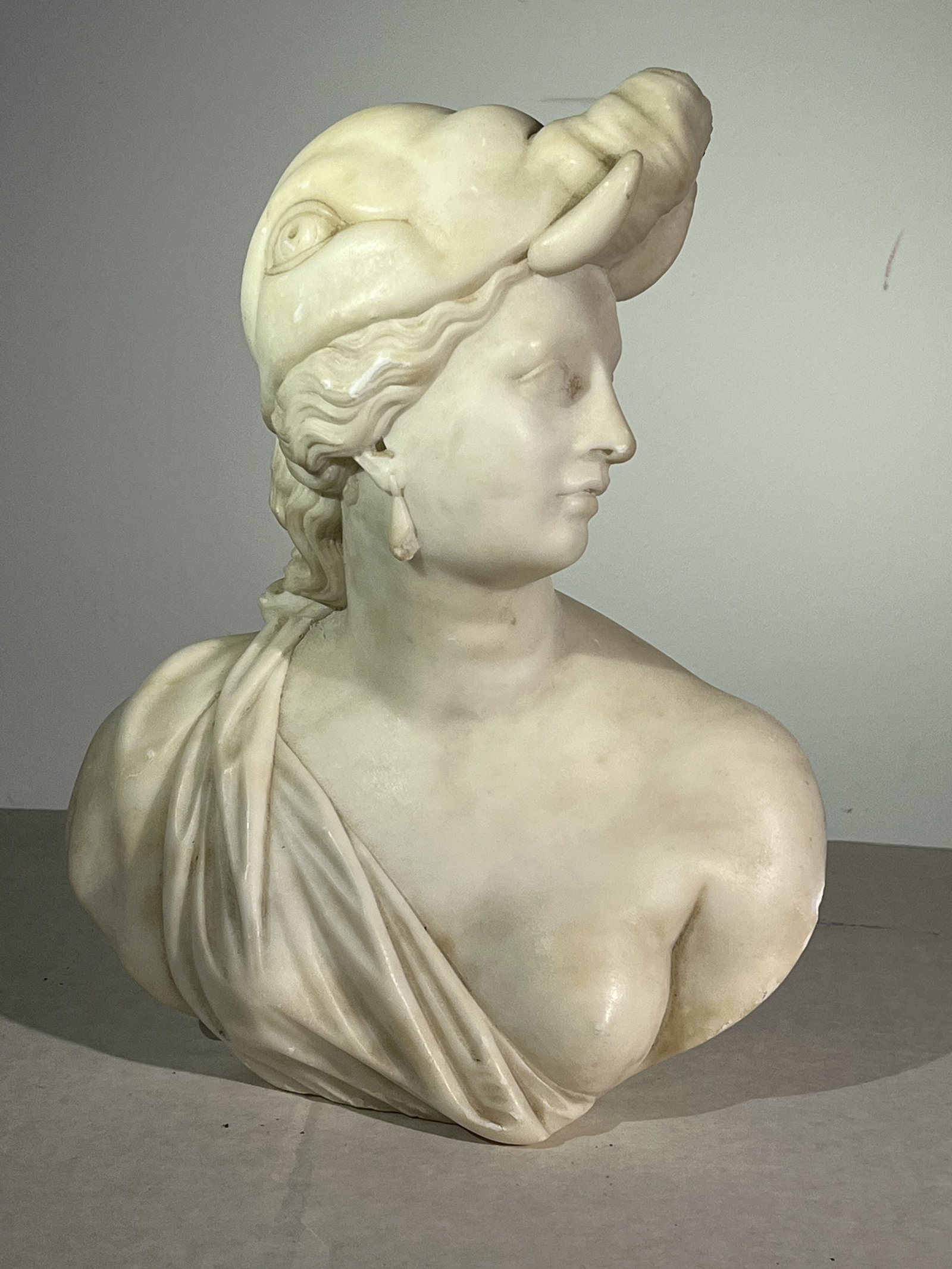 Neoclassical Marble Bust, Female with Headdress: An antique Italian neoclassical bust in white marble, of a woman with an elephant headdress, 19th century.9" w x 4.5" d x 10" h
