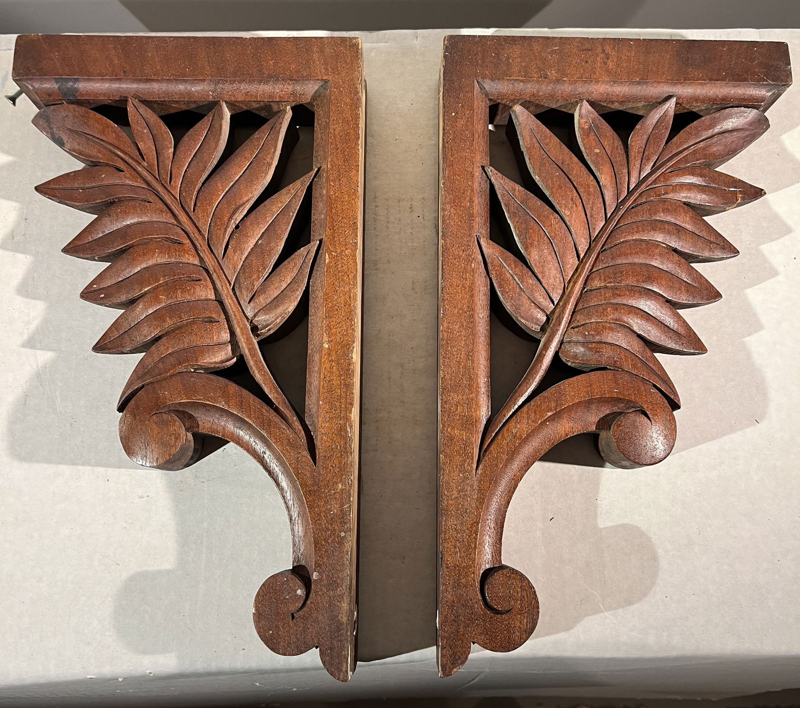 Pair of Teak Wall Brackets: A pair of carved teak wall brackets with palm leaf design, 1920's8" x 15" x 2"