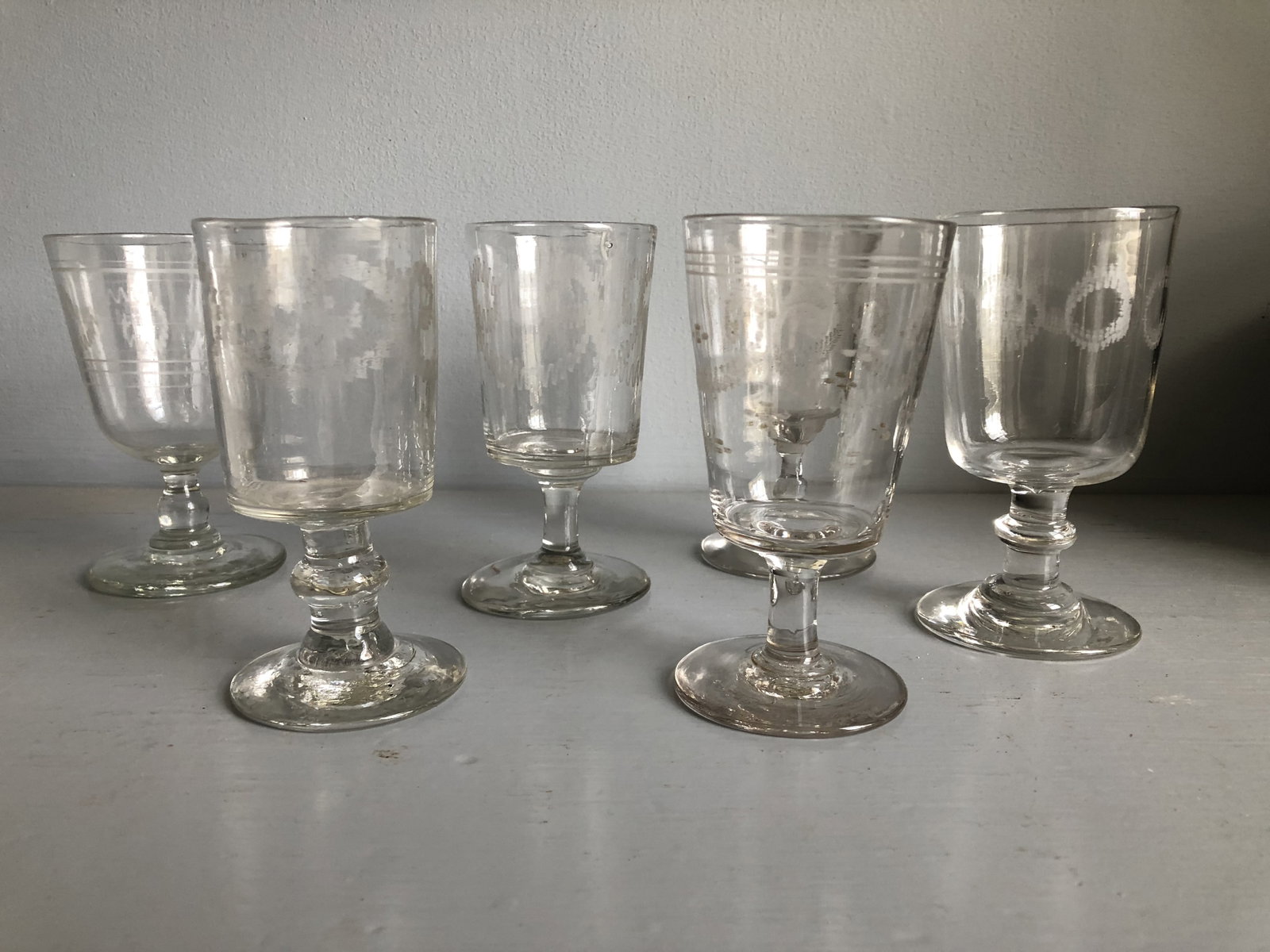 Set of 8 Etched Wine Glasses, Early 19th Century: An assembled set of 8 hand-blown stem wine glasses, each etched with various decoration.3" dia. x 5" h