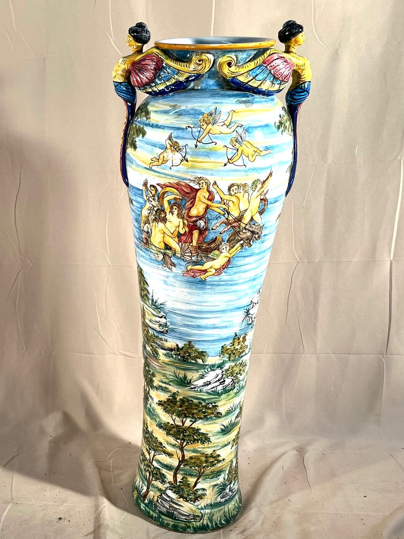 Large Capodimonte Urn: A large Capodimonte urn with angel-form handles and decorated overall with cherubs, and other mythical forms. 40" h x 15" w x 10" d