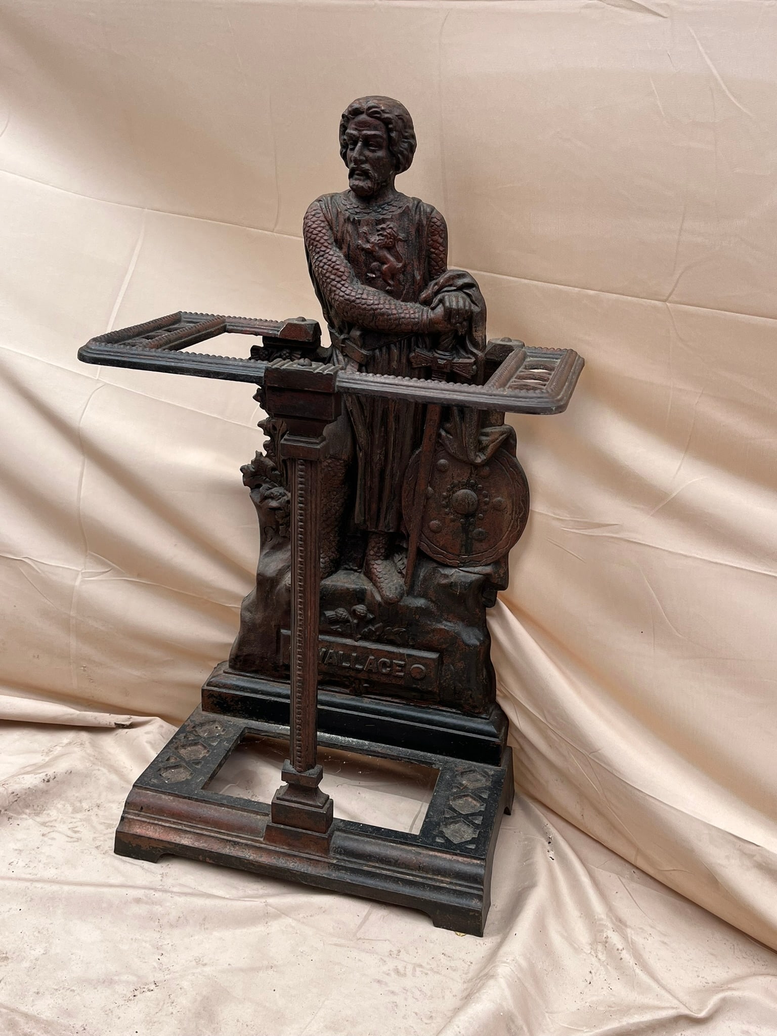 Cast Iron Umbrella Stand, "Wallace": A cast iron umbrella stand with figural backplate depicting the Scottish knight William Wallace. 1920's. 30" h x 18" w x 9" d