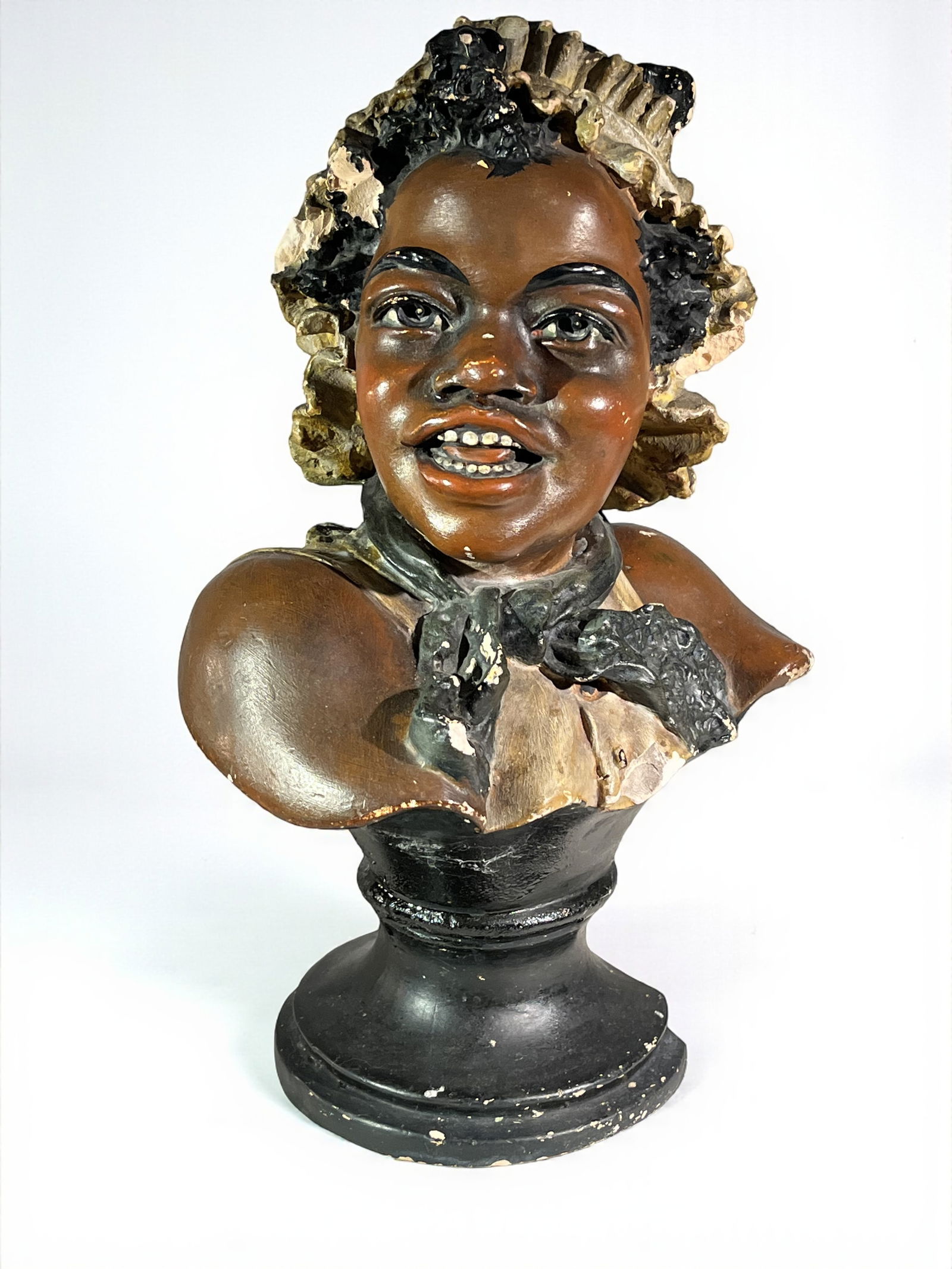Ethnographic Bust of Woman: A painted plaster bust of a laughing black woman, 1930's. 9" w x 6" d x 14" h. Damage to base.