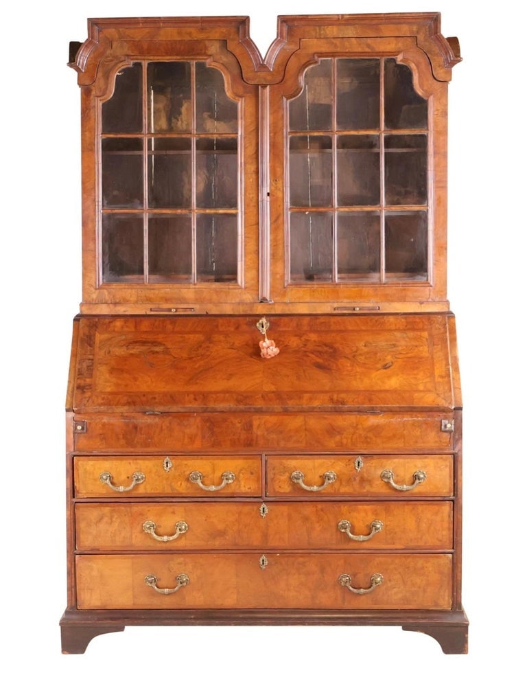 Queen Anne Secretary Desk, Mid 18th Century: A fine Queen Anne style secretary circa 1750, with double arched pediment over a 2-door bookcase with glazed doors, over a slant front desk over 4 lower drawers. 25" d x 54.5" w x 86.5" h