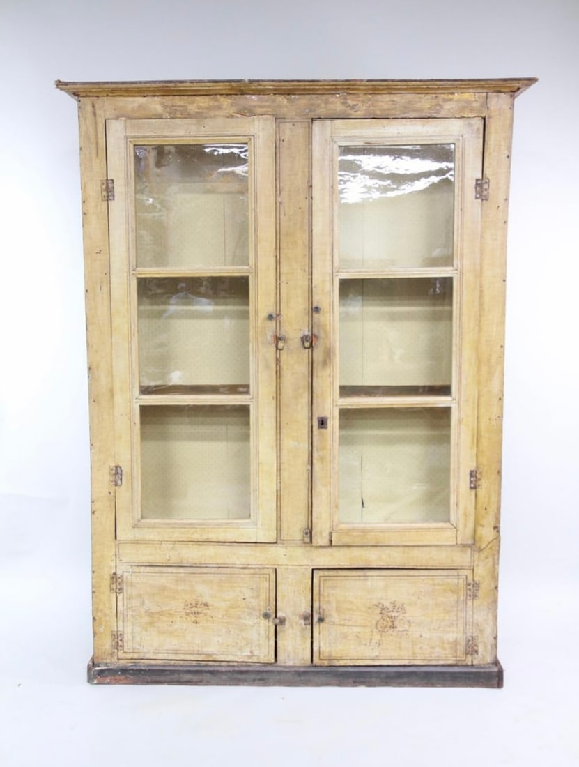 French Louis Philippe Period Painted Vitrine, Circa 1850.: A French Louis Philippe period bookcase, in old yellow painted finish with stencil decoration, two glazed doors over two lower doors. Interior with old wallpaper, shelves. 13.5" d x 44" w x 82" h
