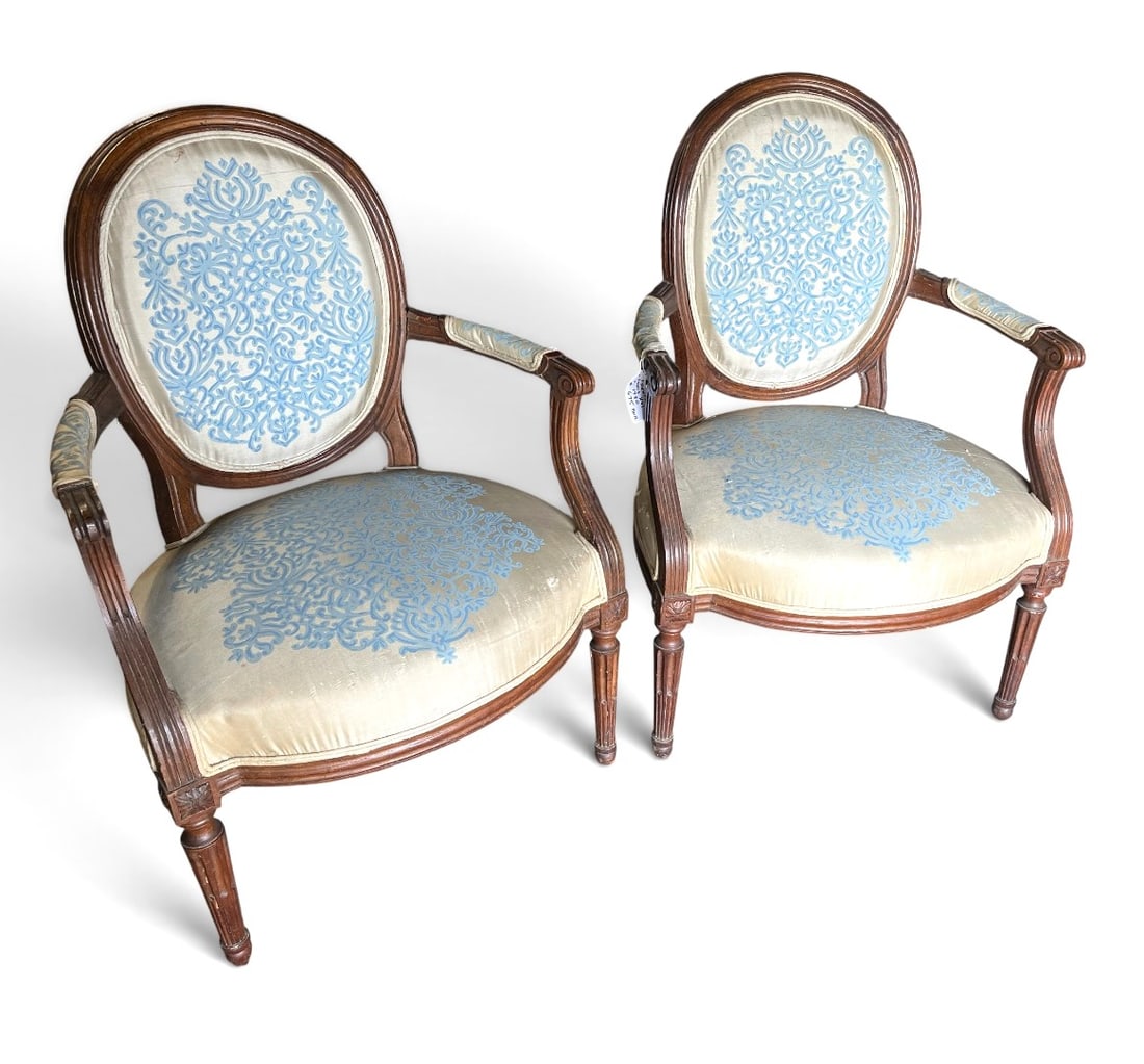 Pair of French Louis XVI Armchairs, Circa 1790: A pair of 18th century Louis XVI fauteuils in dark stained beech, circa 1790, upholstered in cream and blue silk. 25" w x 25" d x 35" h