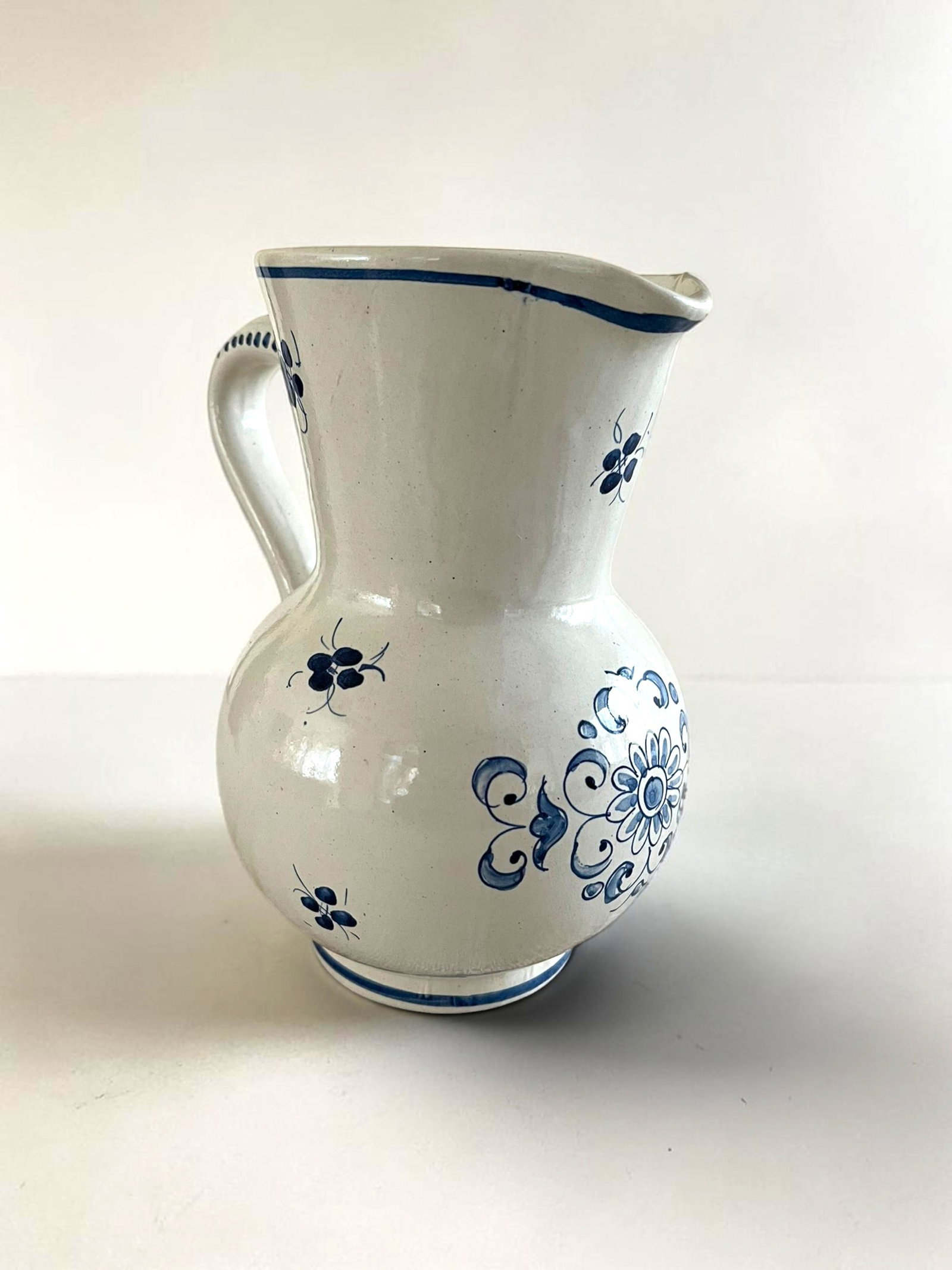 French Faience Blue and White Pitcher: A French faience pitcher in white glaze with blue floral decoration.