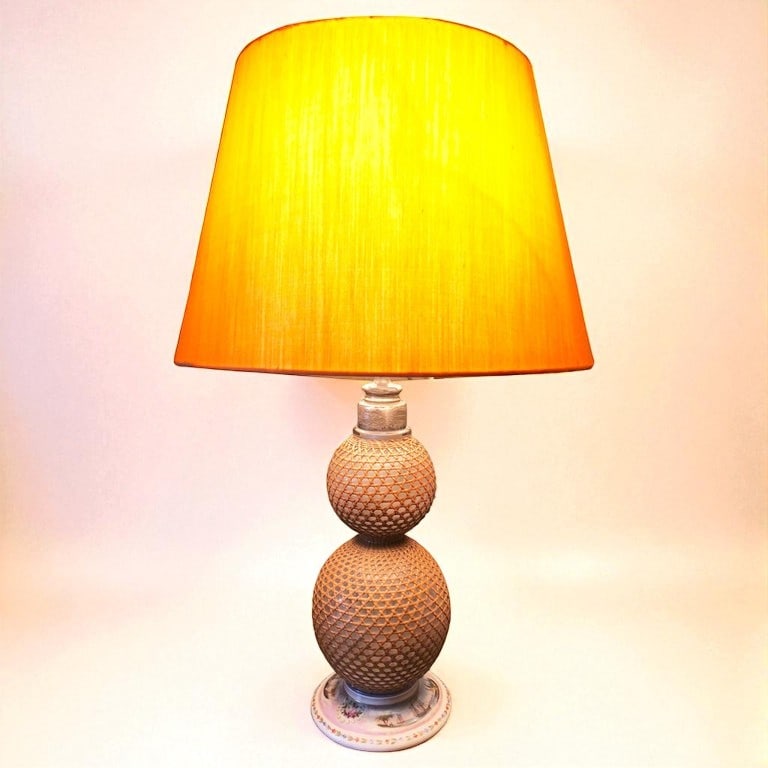 French Syphon Soda Lamp: A French syphon bottle converted to a table lamp, with cane covered glass reservoirs, pewter spigot, and porcelain base with maritime scene in glaze. Circa 1890. 6" dia x 26" h top of shade